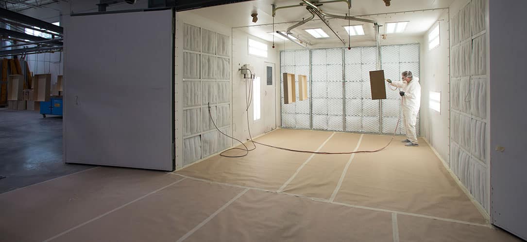 Wood being stained in an open GFS spray booth