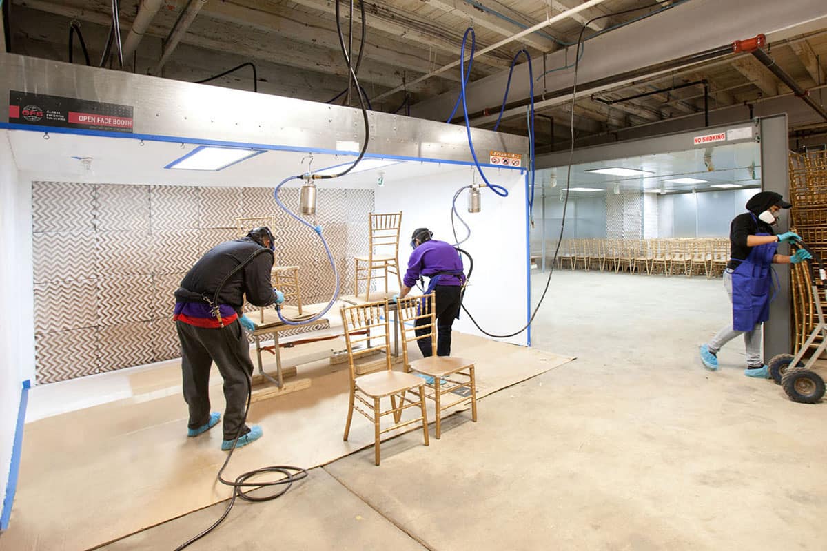 finishing wood chairs in a GFS Open-Face Paint Booth