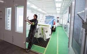 A woman closing a door on a GFS downdraft paint booth